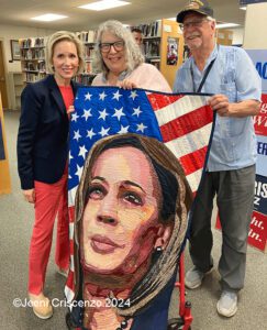 Gwen Waltz with Jeeni Criscenzo displaying Kamala Quilt during event in Manchester NH